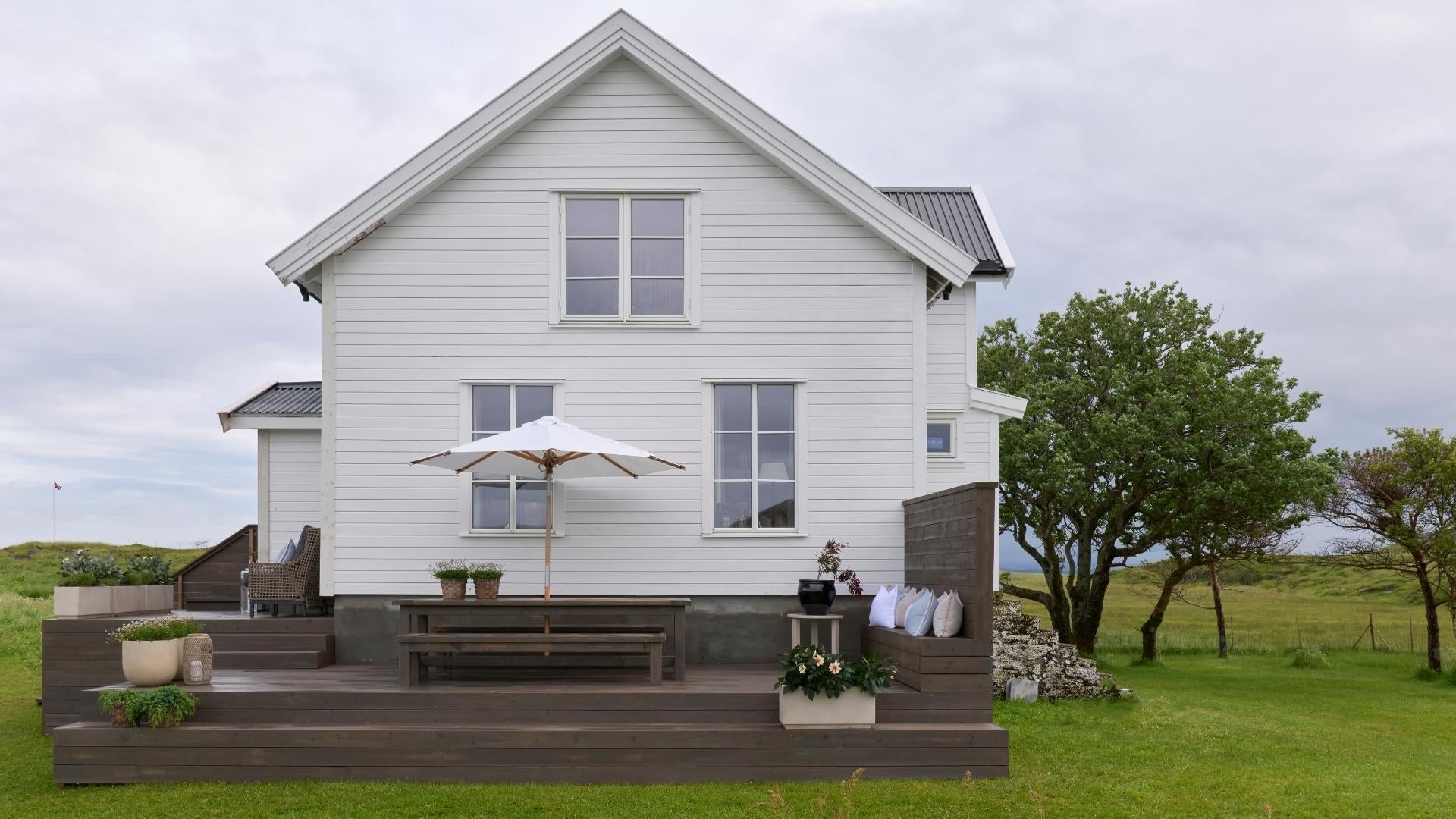 Summer house in lush green landscape.
