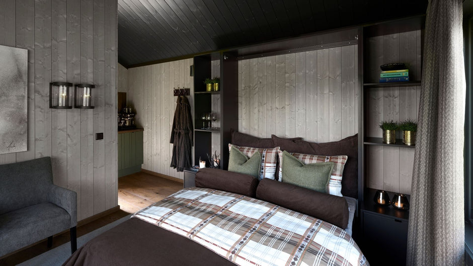 Modern bedroom with a bed, shelves, and a gray sofa.