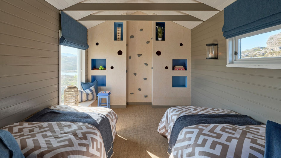 Kinderzimmer mit zwei Betten, einer Kletterwand und farbenfroher Dekoration.