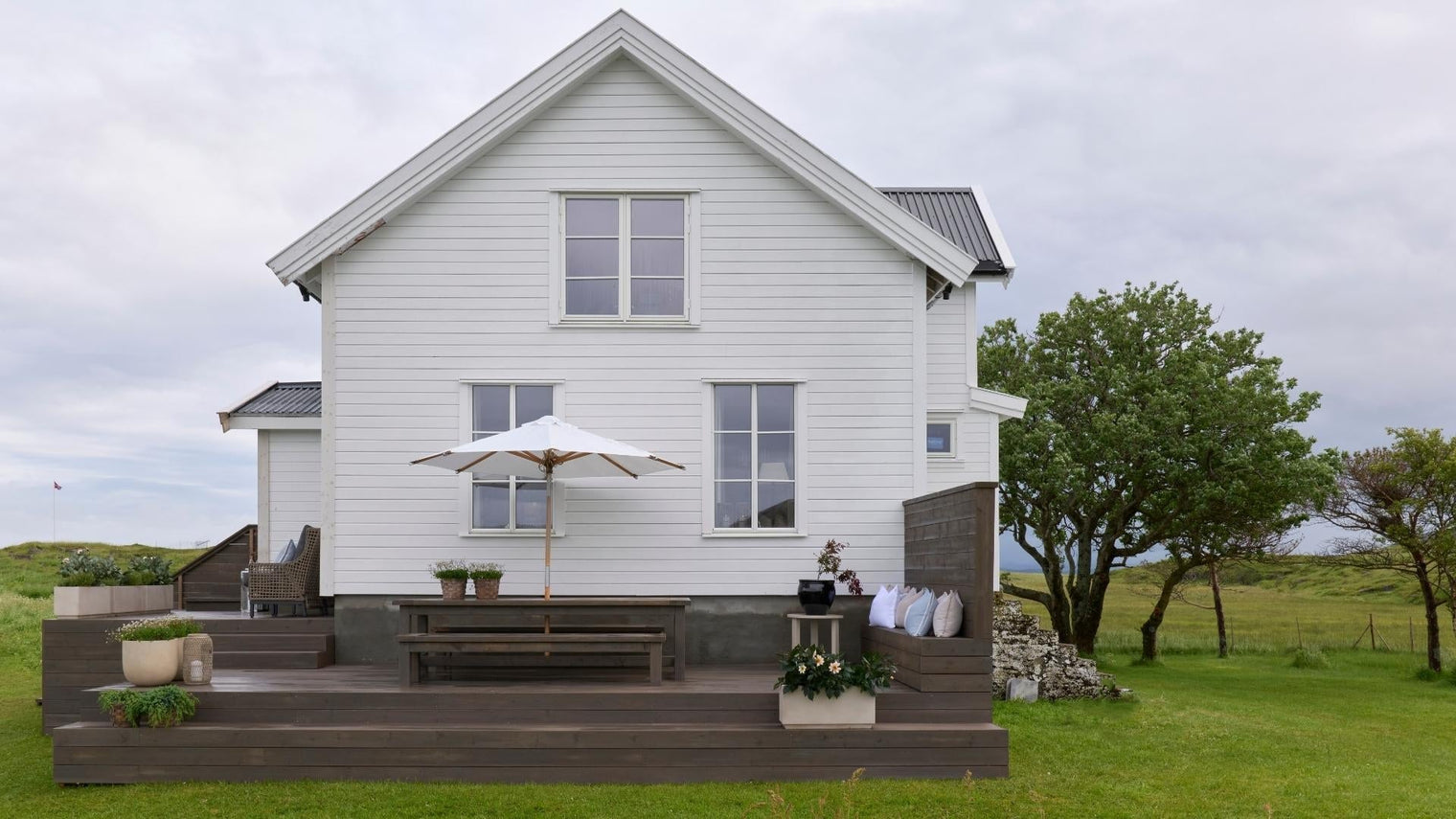 Maison d'été dans un paysage verdoyant.