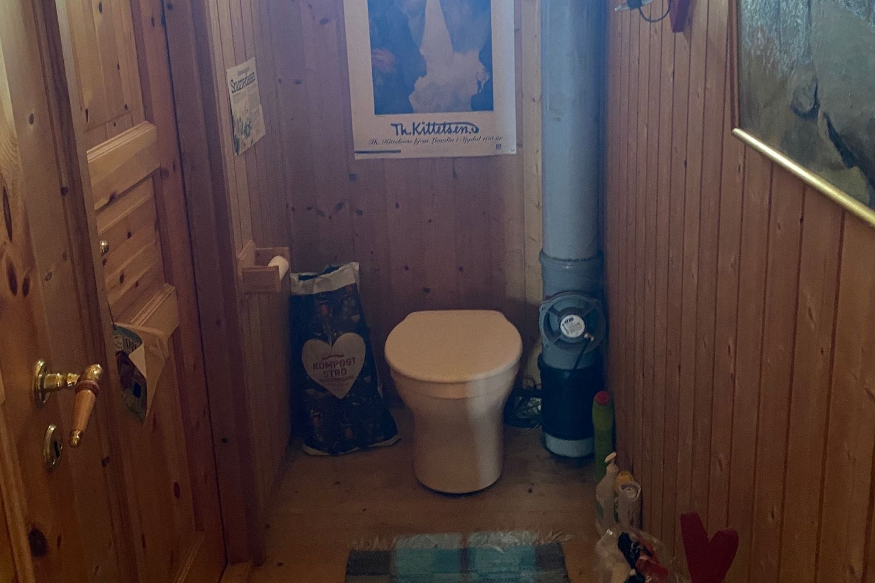 Salle de bain avec des murs en bois et une solution de toilette désagréable.