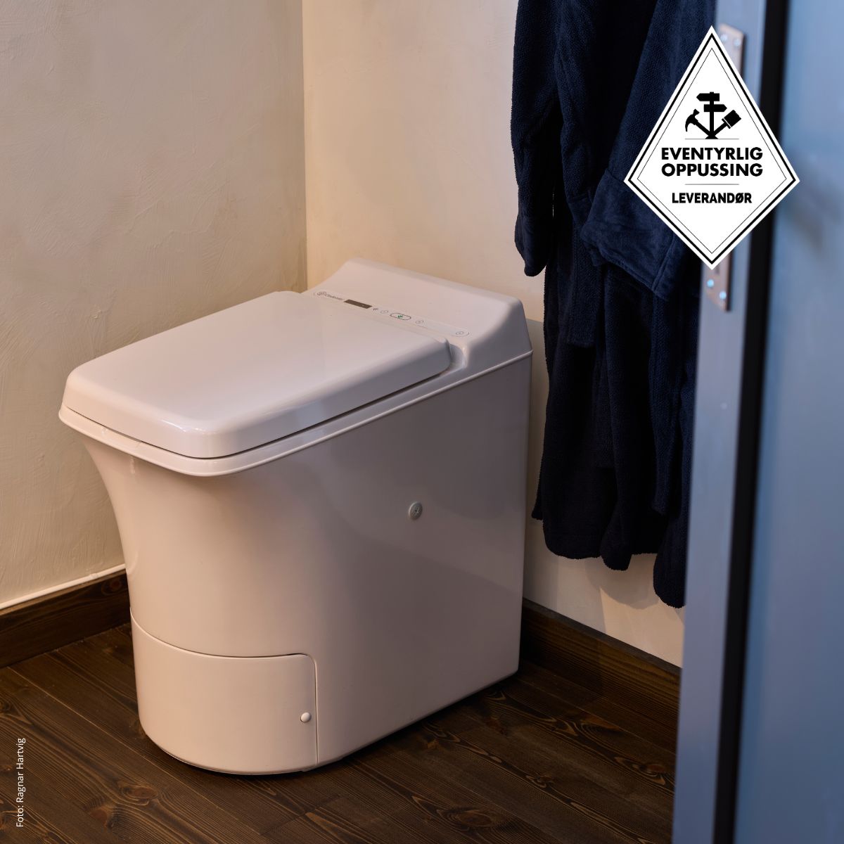 ToilettesFreedom Cinderella Freedom dans une salle de bain avec un peignoir sombre suspendu à un crochet.