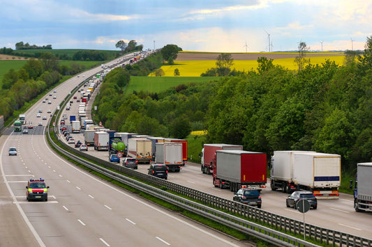 Lang rekke med lastebiler på motorveien. 